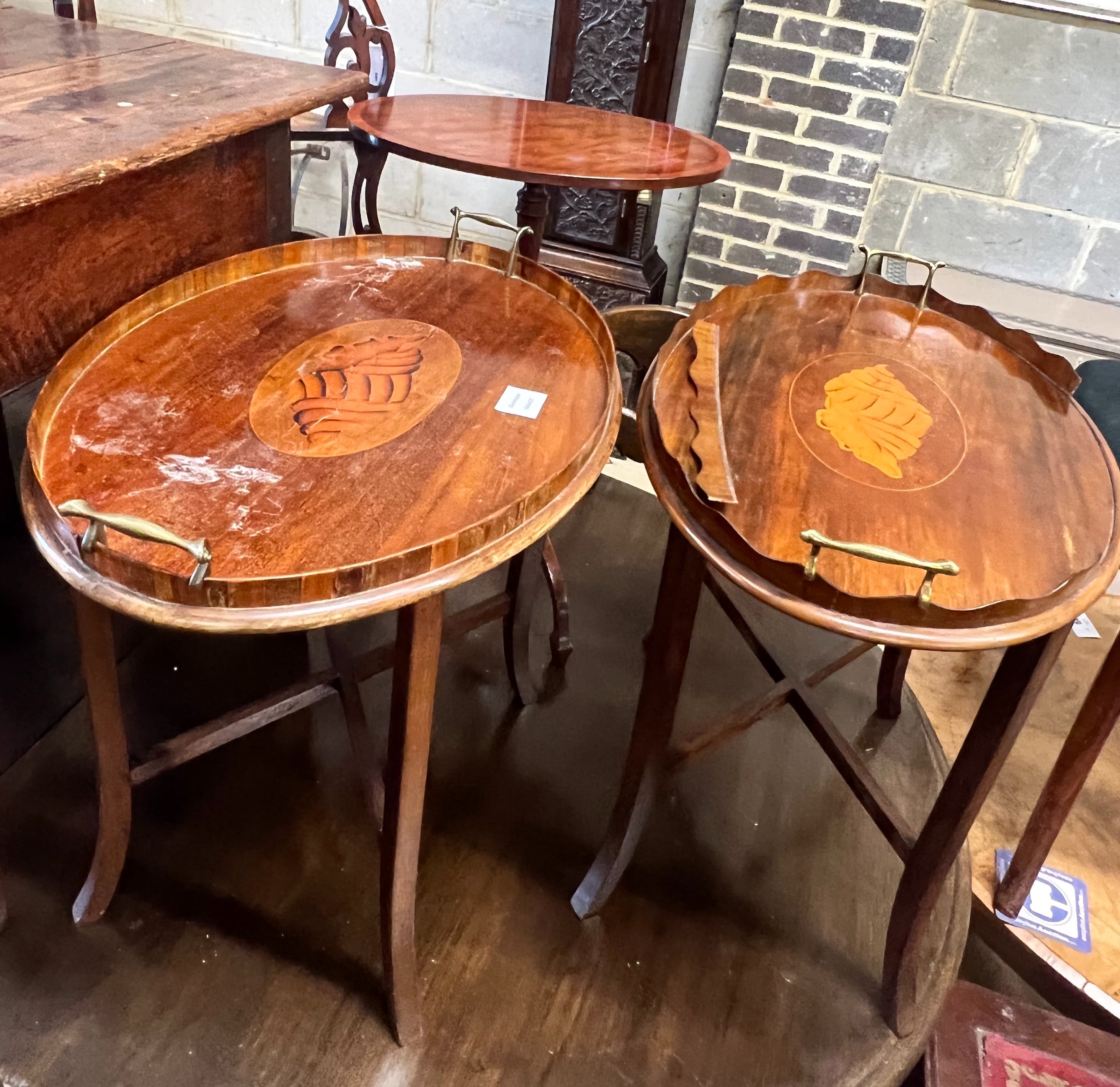 An Edwardian oval tray, with wavy shadow gallery and inlaid shell centre, with later stand and a Victorian mahogany oval tray, with dice work gallery and inlaid oval shell centre, with later stand, and a reproduction tri